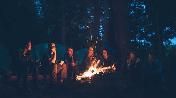 Groupe de voyageurs en bivouac autour d'un feu de camp