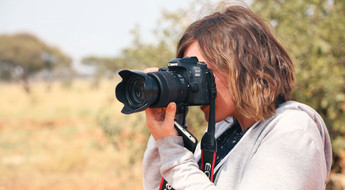 Une femme en train de faire des photos dans la savane