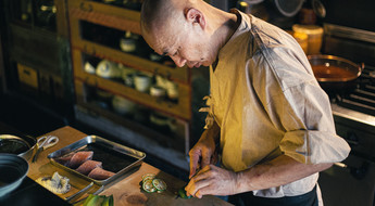 Cuisinier japonais en train de couper des légumes