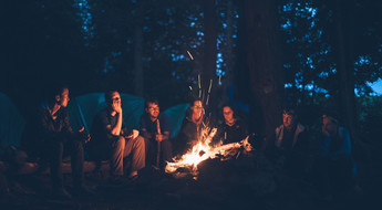 Groupe de voyageurs en bivouac autour d'un feu de camp
