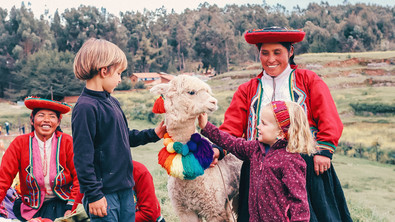 Les enfants découvre un lama joliment déguisé, dans la région de Cuzco au Pérou