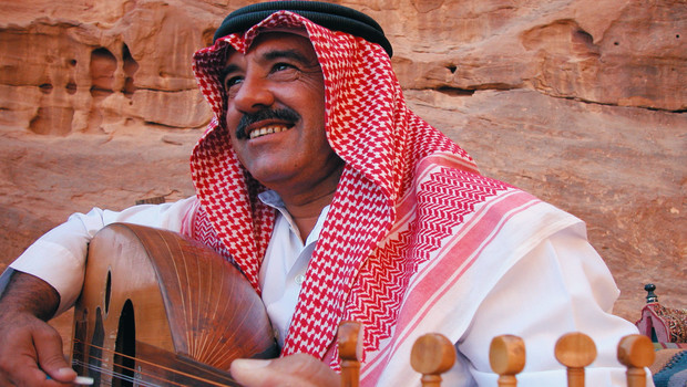 Un Jordanien en habit traditionnel jouant du oud
