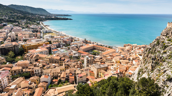 Station balnéaire sicilienne bordée par une mer turquoise et des falaises escarpées
