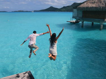 Couple sautant dans un lagon