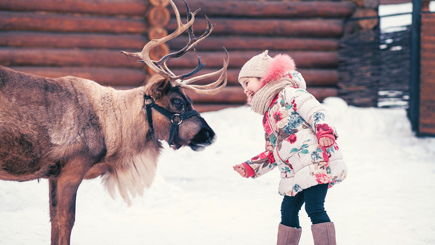 Child with a reindeer in Finland