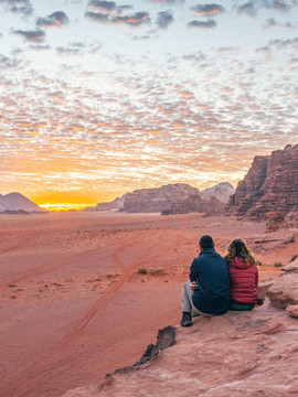 Couple admirant le coucher du soleil dans le Wadi Rum